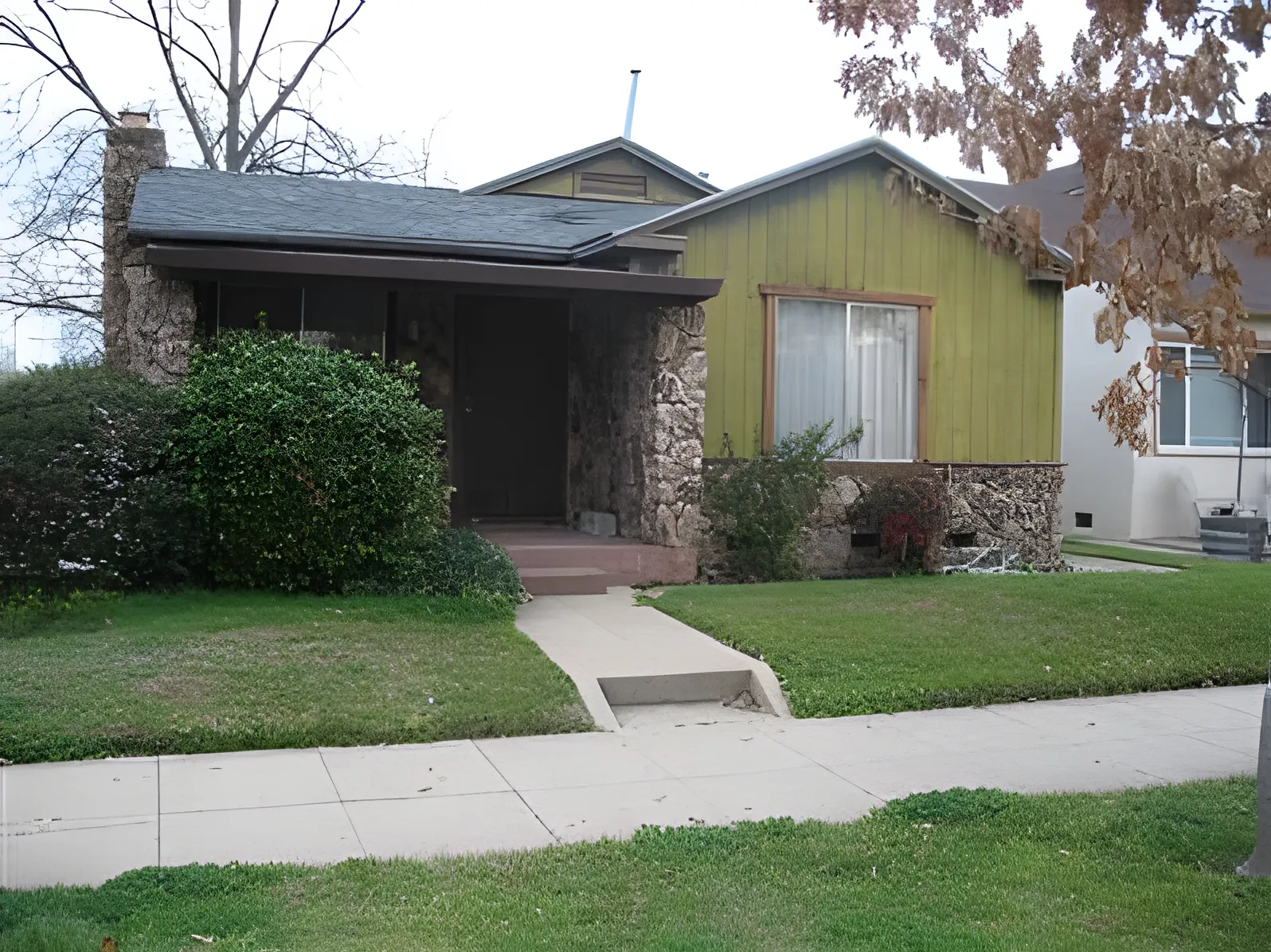1494 34th Street before - neglected bungalow with stone facade and faded green siding