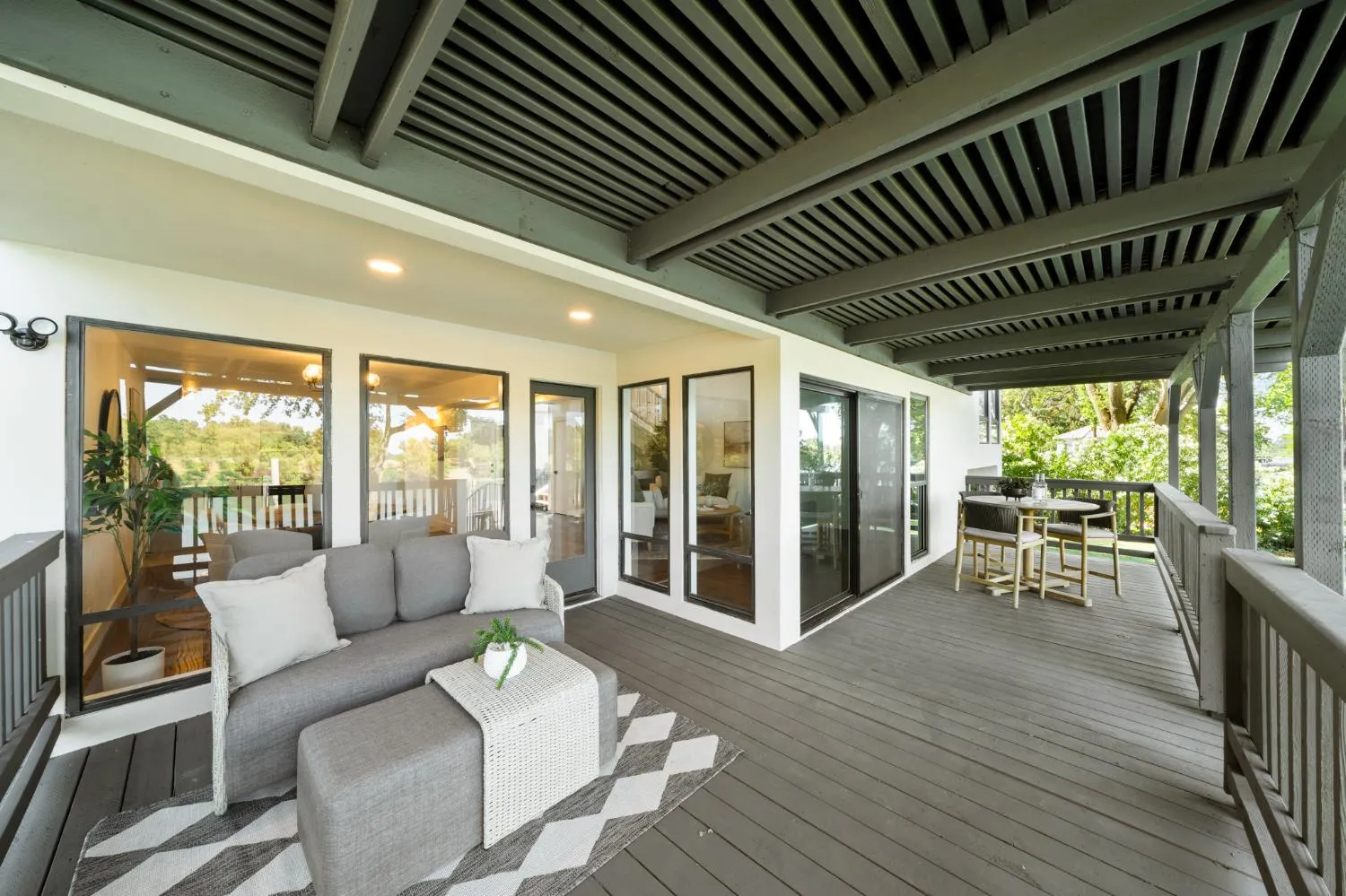 Wraparound covered deck with outdoor seating and new decking