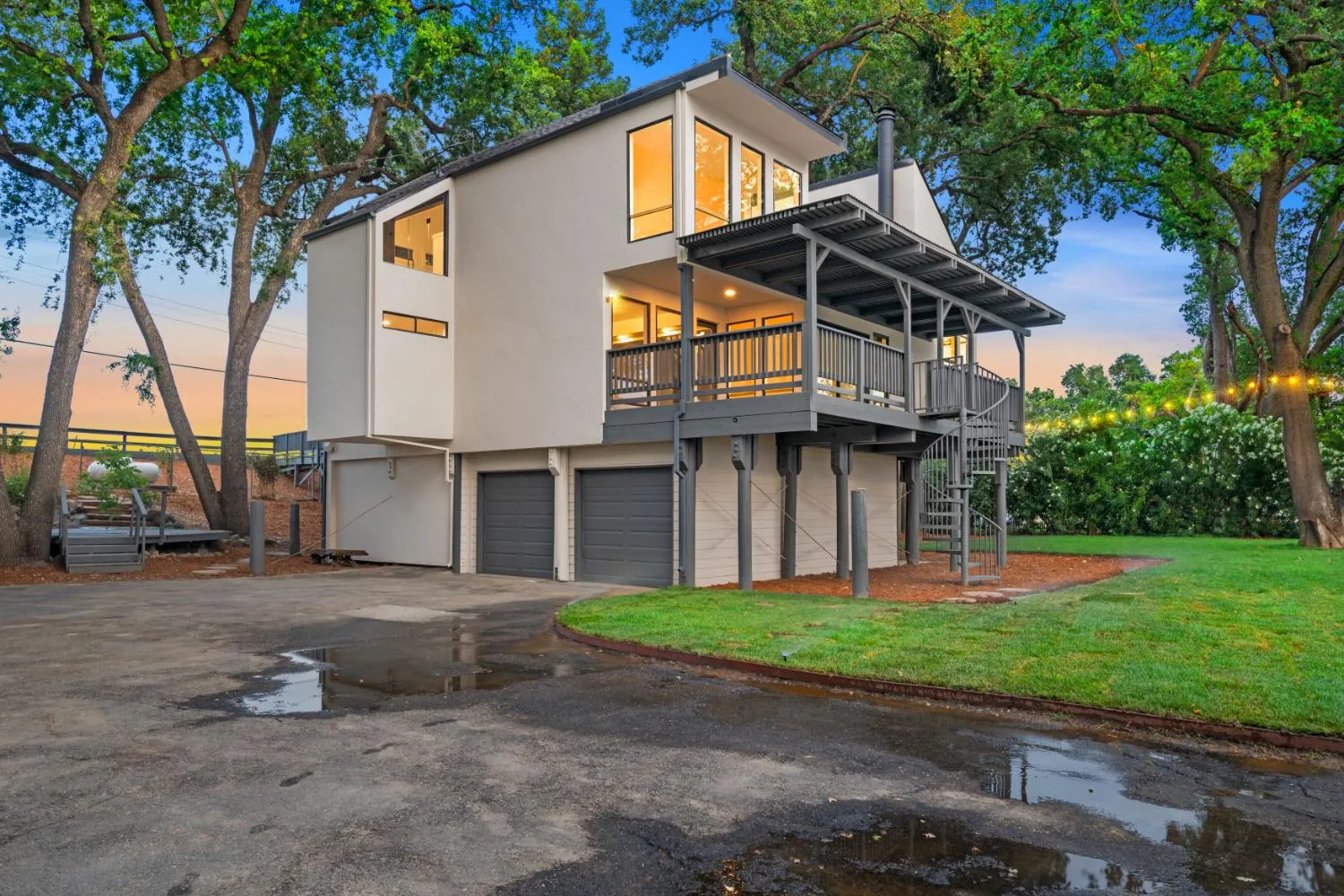 3777 Garden Highway after renovation at dusk - new stucco exterior, refinished wraparound deck, and new landscaping