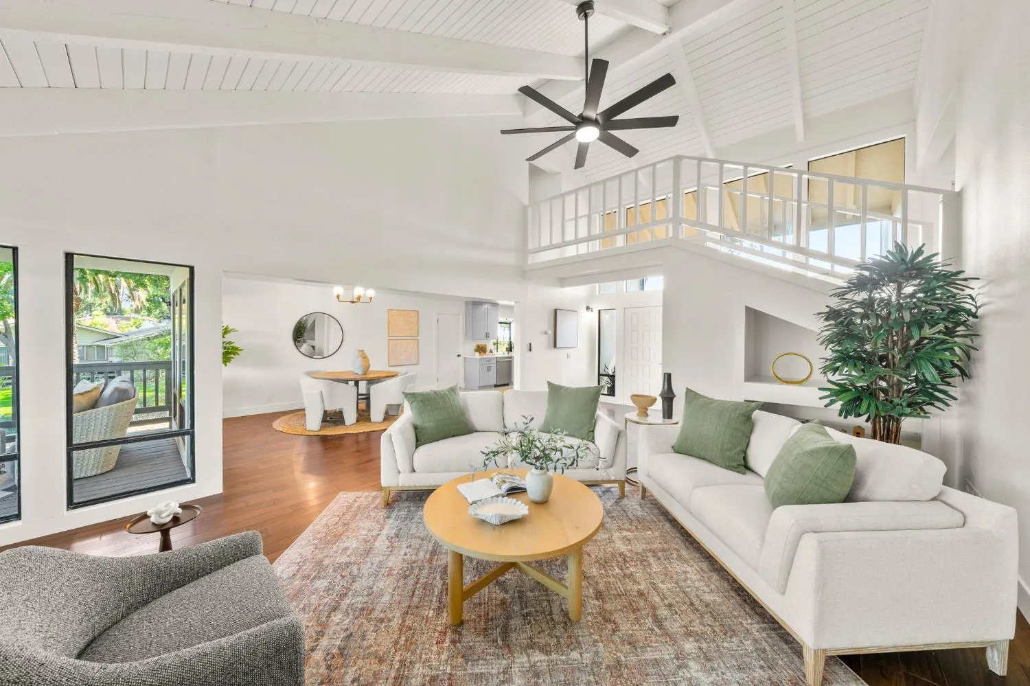 Great room at 3777 Garden Highway with vaulted ceiling, loft railing above, and staged seating