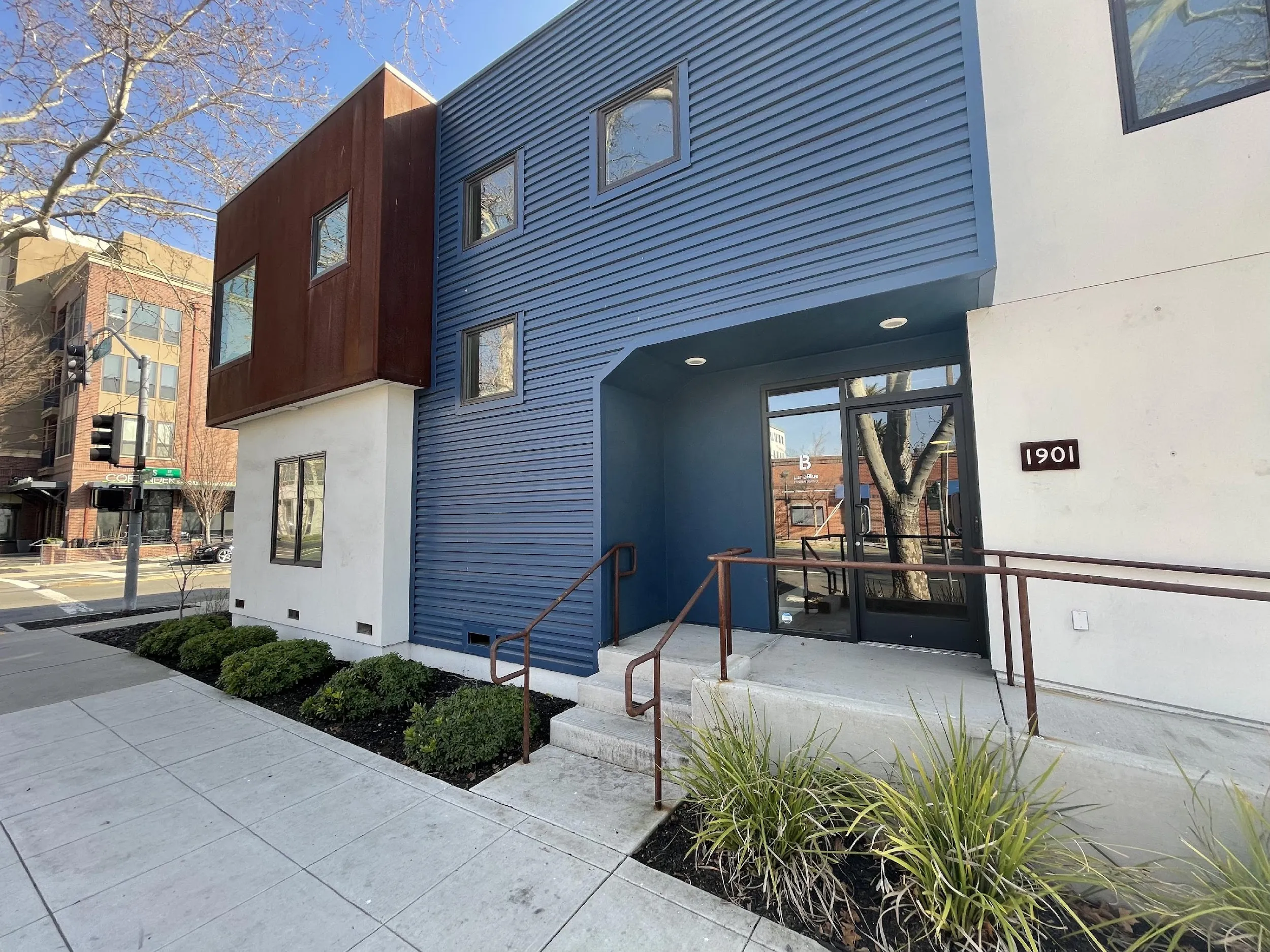Renovated commercial building at 1901 Alhambra Boulevard Sacramento with blue metal siding and corten steel accent
