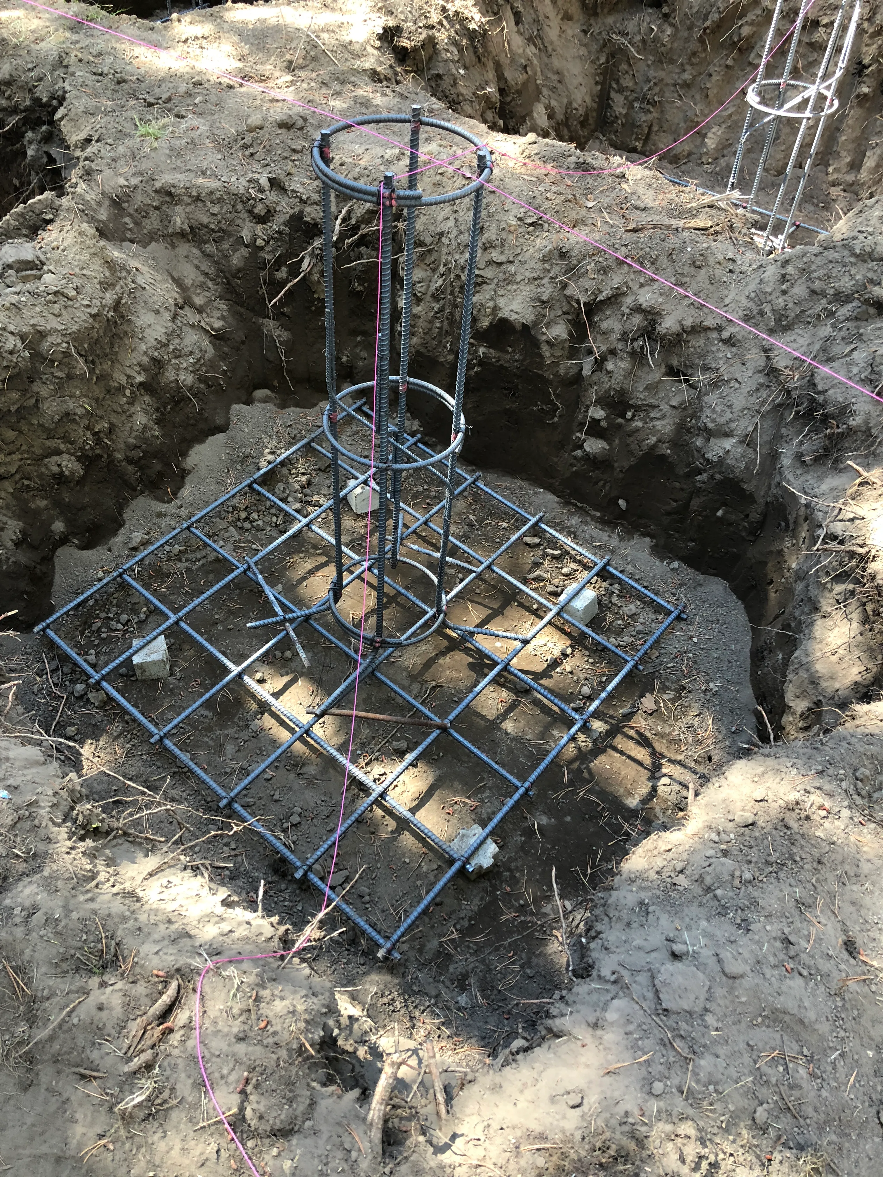 Rebar cage set in excavated foundation footing for the cabin addition